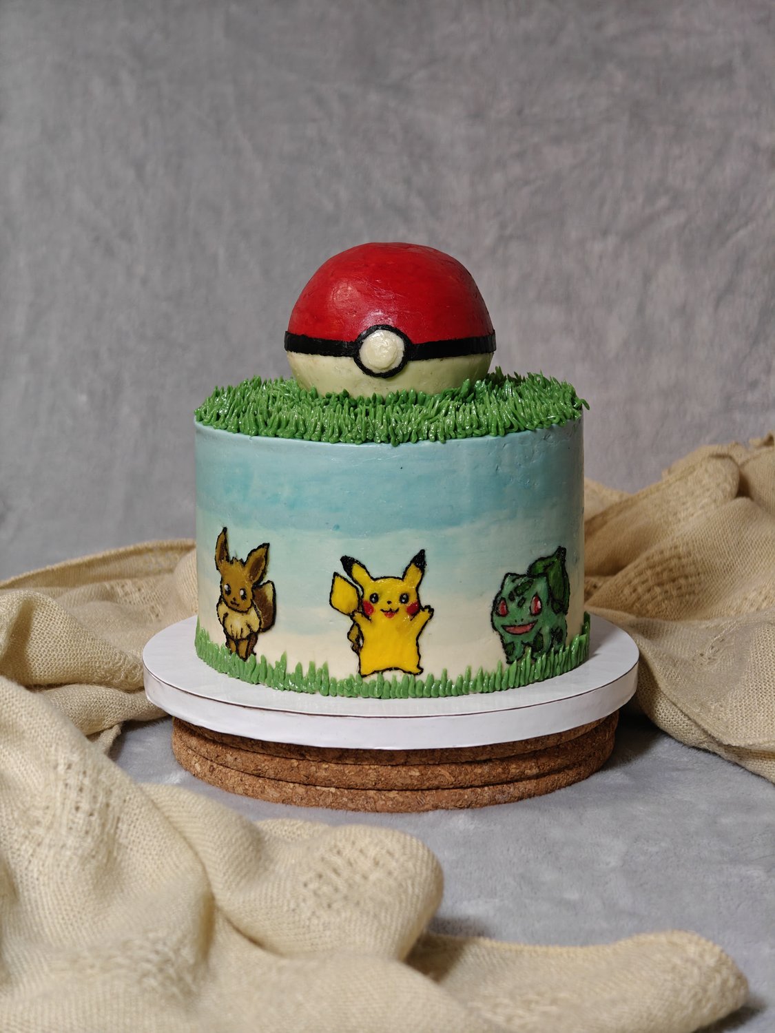 Two-tier Pokemon themed cake with Pikachu and friends